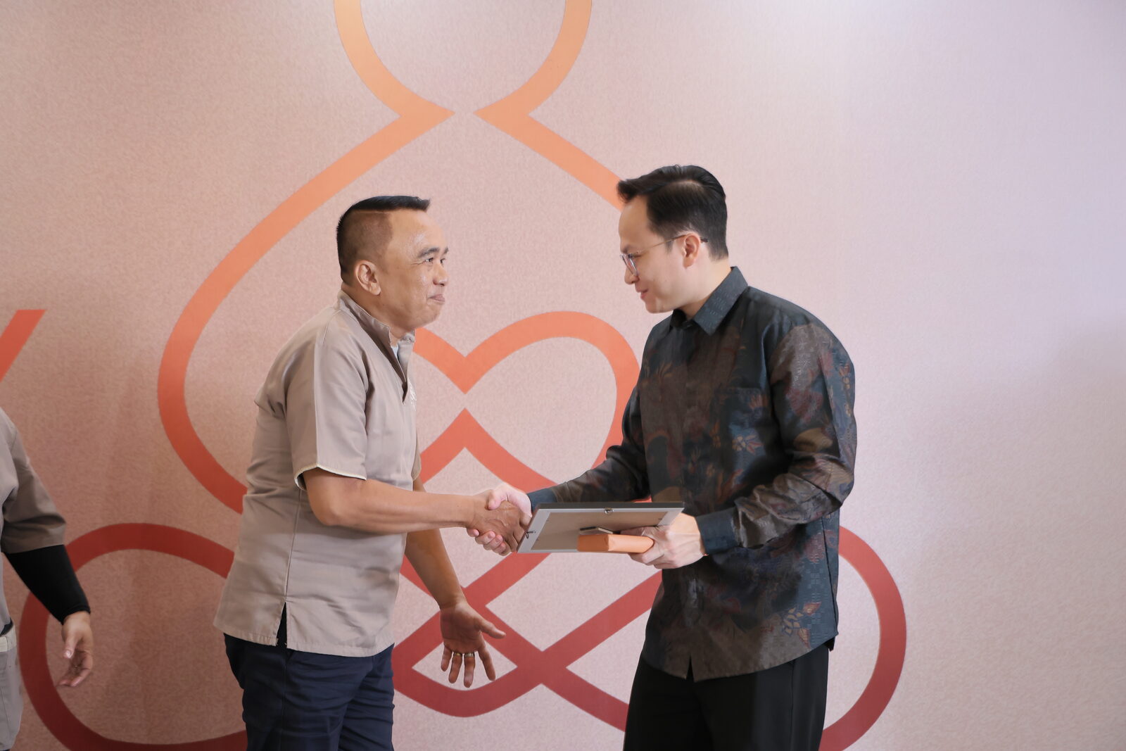 Owner Truly Home Massage berjabat tangan dengan terapis laki-laki penerima penghargaan terapis terbaik